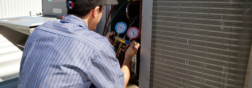 HVAC technician servicing a condenser unit in New Haven