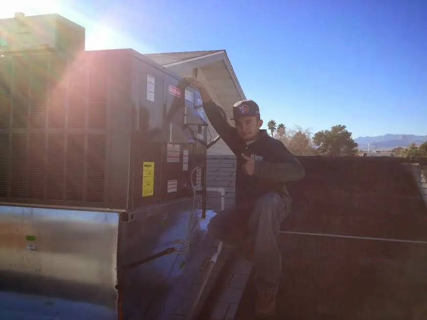HVAC technician performing Boiler Repair on a rooftop unit in New Haven